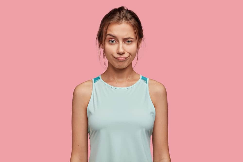 How To Sew A Tank Top In Four Easy Steps? 1 discontent caucasian woman raises eyebrow pouts lips