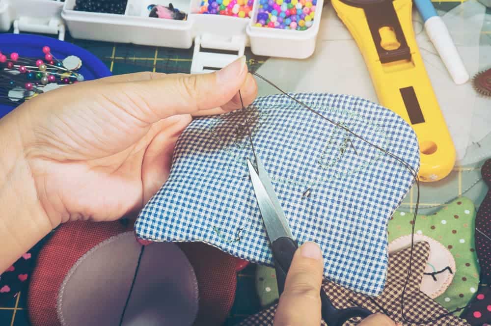 woman is doing needlework with other embroidery equipment table