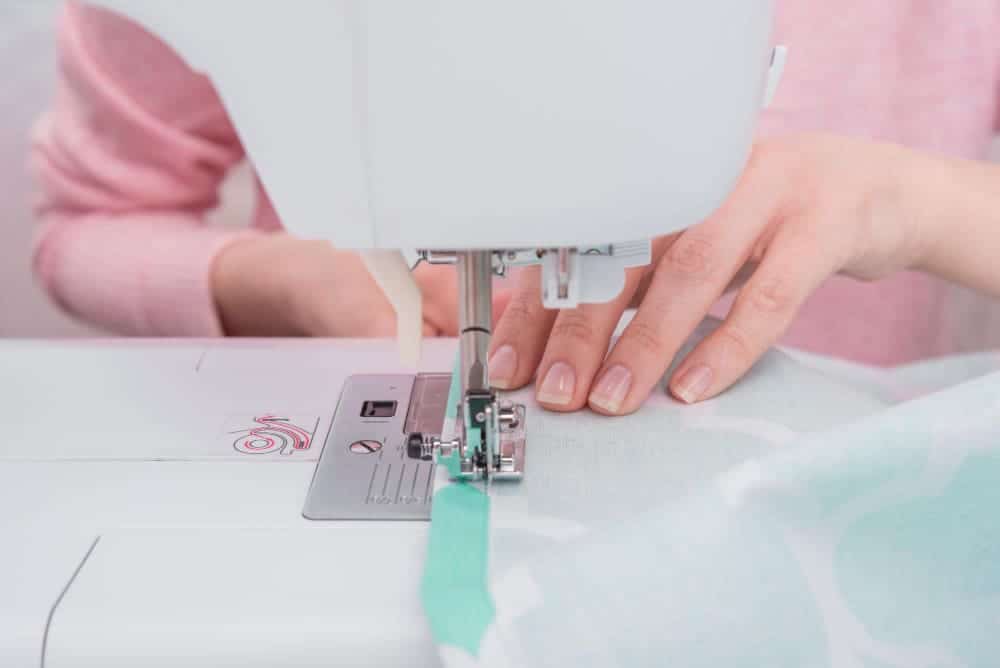 How Long Does It Take To Sew A Dress If You Do It Without Sewing Machines 2 womans hadns workin sewing machine