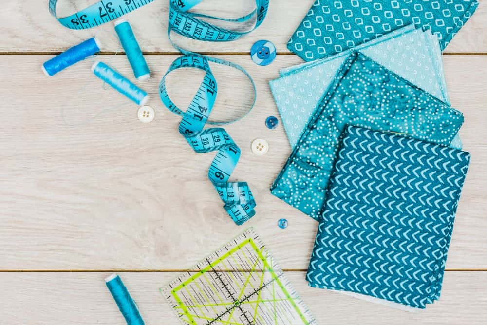 blue thread measuring tape buttons ruler folded print clothes wooden desk