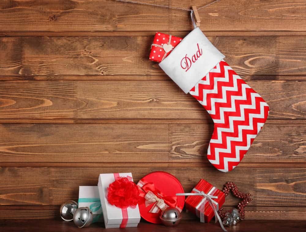 How To Sew Names On Stockings for Chritsmas 4 christmas stocking presents against wooden wall