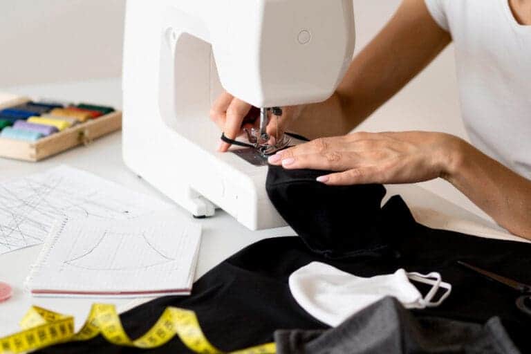 high angle person sewing face mask