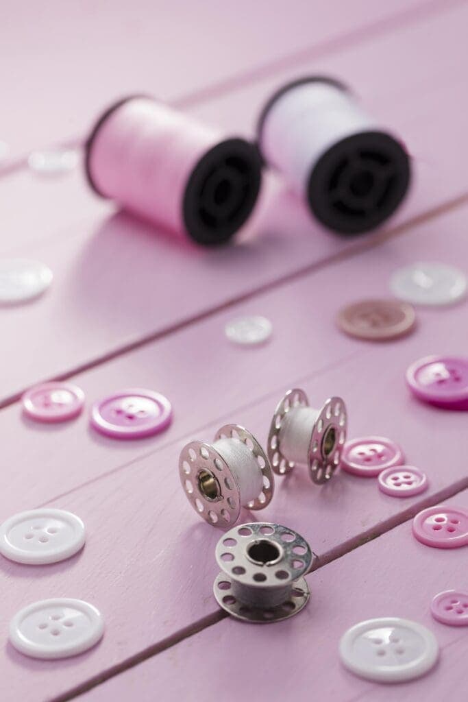 How to Sew Snap Like A Pro? 2 high angle sewing machine shuttles with buttons thread