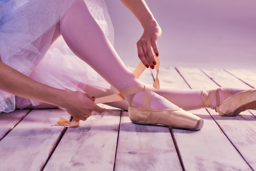professional ballerina putting her ballet shoes