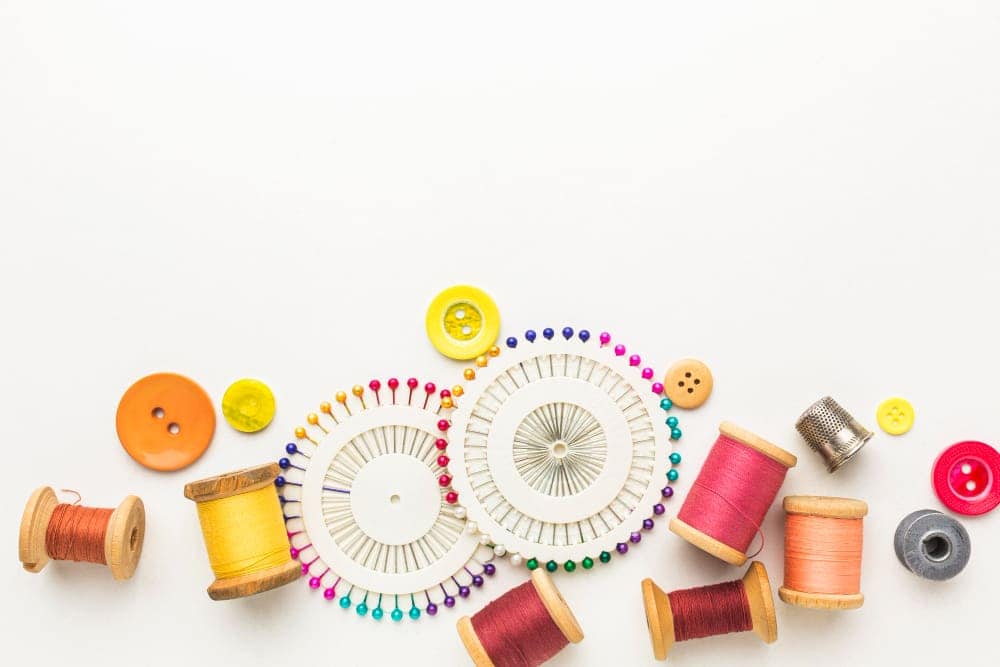 Can You Use Embroidery Thread On A Sewing Machine? 3 top view thread with needles buttons